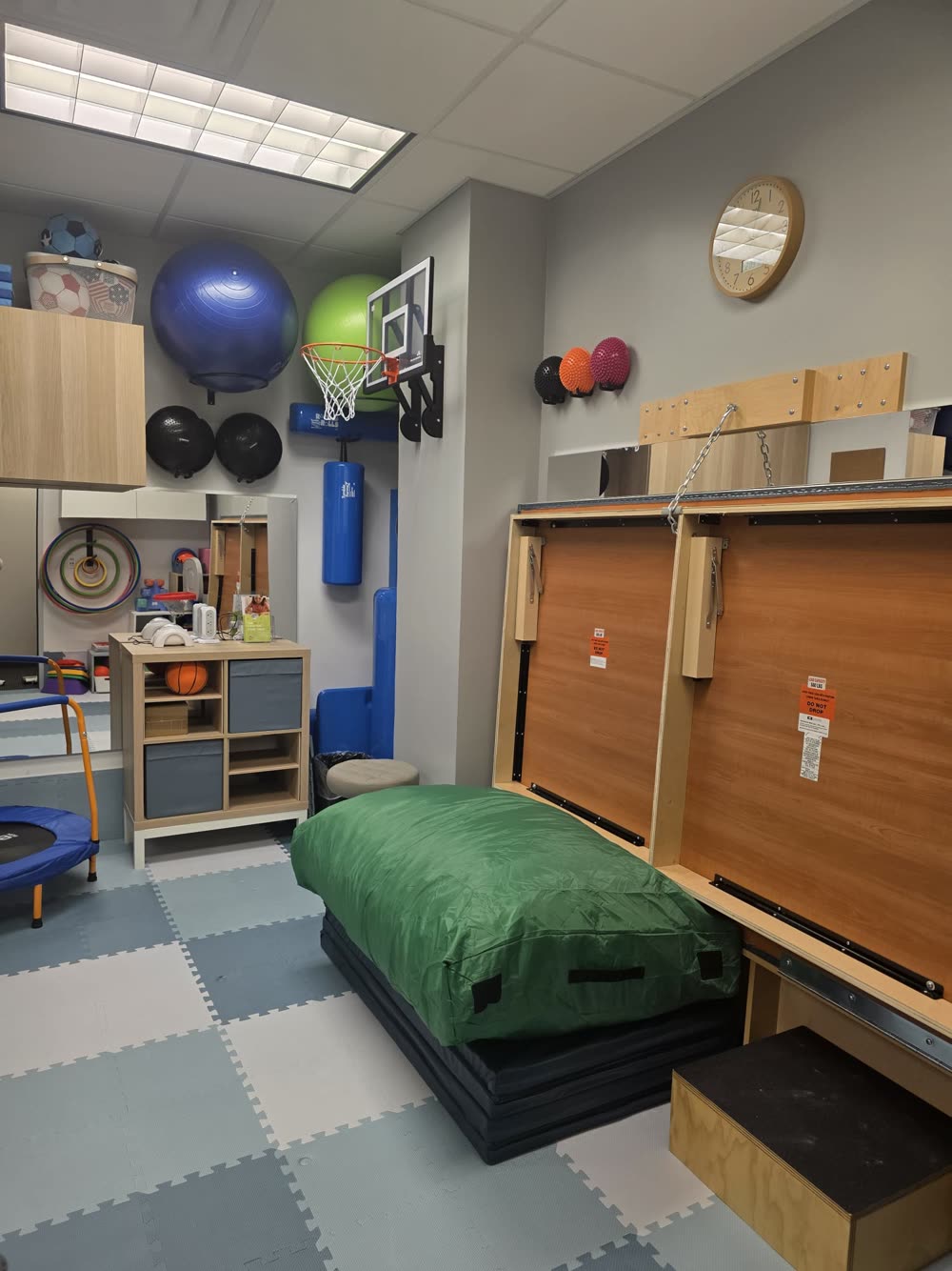 Therapy gym with a crash mat, mini trampoline and therapy balls